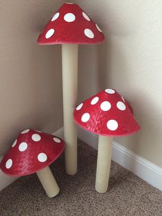 three mushroom shaped stools sitting next to each other on the floor in front of a wall