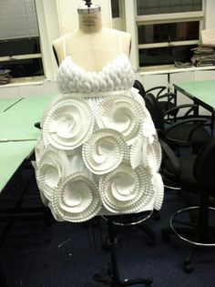 a dress made out of paper plates sitting on top of a table