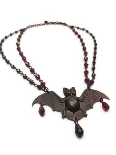 ~ A one-of-a-kind original design by Mary @ Vexed! ~ Gorgeously detailed black bat made of solid brass and decorated with garnet glass drops ~ Measures a whopping 3 1/2" wide x 1 1/2" high  ~ Two strands of hand-linked dark garnet red Czech faceted glass beads ~ Necklace measures approximately 15 inches and is adjustable up to 19 inches VEXED JEWELRY: SPOOKY, BLASPHEMOUS, ONE-OF-A-KIND AND LIMITED EDITION HANDCRAFTED JEWELRY MADE WITH LOVE, SPITE, CARE, BLOOD, SWEAT, TEARS, SASS, EXPERTISE & TOP Faceted Glass Bead Necklace, Bat Pendant, Victorian Vampire, Dark Garnet, Beaded Rosary, Vampire Bat, Gothic Victorian, Rosary Necklace, Black Bat