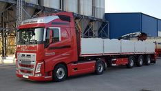 a red semi truck parked in front of a building