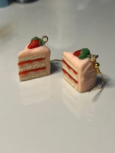 two pieces of cake with strawberries on them are sitting on a white counter top