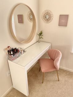 a white desk with a mirror and pink chair next to it in a room that has carpeted flooring