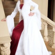 a woman in a white fur coat and red dress standing on stairs with her hands on her hips