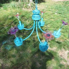 a blue chandelier sitting on top of a lush green field