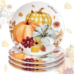 three plates with painted pumpkins and flowers on them, all stacked up in front of each other