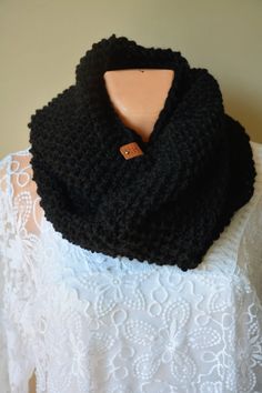 a black knitted cowl sitting on top of a white dress