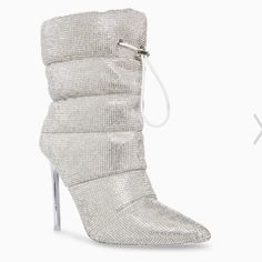 a pair of silver high heel boots with zippers