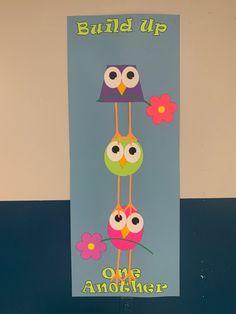 a sign with owls hanging from it's sides that says build up one another