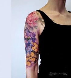 a woman's arm with flowers painted on it and the top half of her sleeve