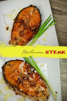 two pieces of meat on a white plate with green onions and seasoning sprinkles