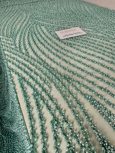 a close up of a table cloth with water drops on it and a price tag