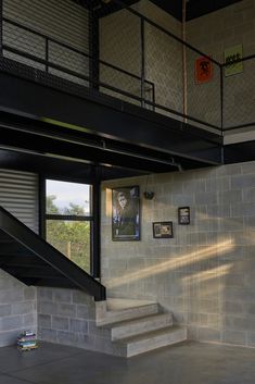 the stairs lead up to the second floor in this modern house with stone walls and steel railings