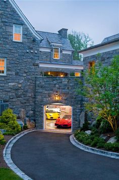 a car is parked in the entrance to a large stone house with a driveway leading into it