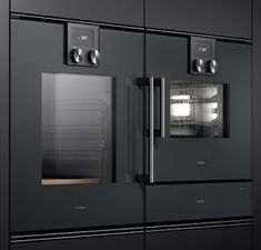 two ovens side by side with one door open and the other closed, in front of black cabinets