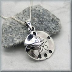 "This necklace features a beautifully detailed sand dollar pendant. Highly polished and absolutely lovely - the perfect necklace for summer! Pendant is a bit more than 1/2\" long (16 mm). All components, including box chain, are sterling silver. Coordinating earrings can be found here: https://www.etsy.com/listing/277982012/sand-dollar-earrings-sterling-silver?ref=shop_home_active_68 Jewelry is packaged in a cotton lined box for gift-giving. See more Bonny Jewelry at http://bonnyjewelry.etsy.com Engraved Pendant Necklace For Beach, Sterling Silver Pendant Necklace For Beach, Silver Engraved Necklace For Beach, Sand Dollar Art, Summer Pendant, Sand Dollar Earrings, November Birthstone Jewelry, Sand Dollar Necklace, Sand Dollar Pendant