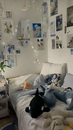 a bed with stuffed animals on it in a room filled with pictures and lights hanging from the walls