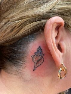 a woman with a small tattoo on her left ear