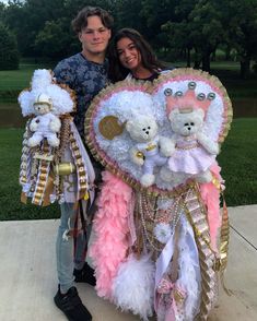 a man and woman standing next to each other holding teddy bears in front of them