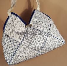 an origami bag with blue and white designs on the front, hanging from a string