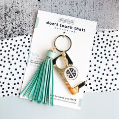 a keychain with a tassel on it sitting on top of a piece of paper