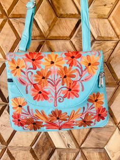 This handcrafted 100% leather shoulder bag with a beautiful floral embroidery is incredibly modern and it's lavish colour schemes make it easy to theme this stylish bag with your everyday outfits..  Handmade by skilled Kashmiri artisans, Inside it has a black lining and features 3 compartments, from which 2 with a zipper.  It is big enough to carry a cell phone, id, lipstick and other items you need to take with you in your everyday life. It has adjustable  crossbody straps. Closes by a magnetic button clasp.  The size is 23,5 cm length x 18,5 cm height. - 100 % Natural  leather A chic elegance that never goes out of style. THE VIDEO IS REPRESENTING THE SAME ITEM IN ANOTHER COLOR TO SHOW THE FUNCTIONALITY OF THE ITEM. PLEASE CHECK OUR COMPLETE COLOR COLLECTION. The photos are an estimate o Multicolor Embroidery Crossbody Shoulder Bag, Leather Shoulder Bag With Floral Embroidery, Blue Bags With Floral Embroidery For Daily Use, Turquoise Travel Bag For Spring, Daily Use Blue Bags With Floral Embroidery, Spring Travel Turquoise Bags, Leather Shoulder Bag With Floral Embroidery For Travel, Leather Shoulder Bag With Floral Embroidery For Daily Use, Spring Gift Leather Shoulder Bag