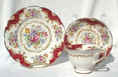 two plates and a cup on a white tablecloth with red trimming around the edges