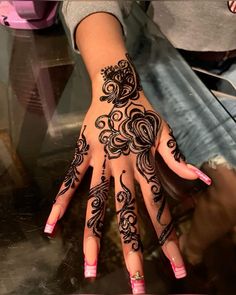 a woman's hand with henna tattoos on it