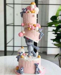 a three tiered cake decorated with teddy bears and balloons