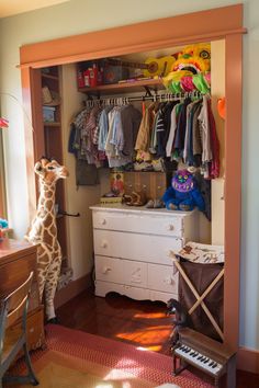 a giraffe standing next to a dresser in a bedroom