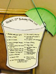 a paper cup with a green umbrella attached to the top and writing on it that says nicole's 21st birthday check list