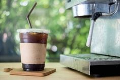 a coffee cup sitting on top of a wooden table next to an espresso machine