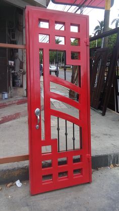 a red door is open on the sidewalk