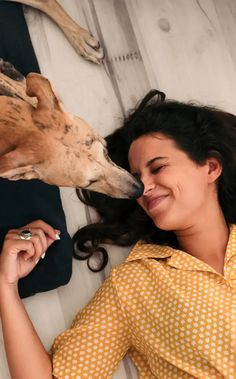 a woman laying on the floor next to a dog