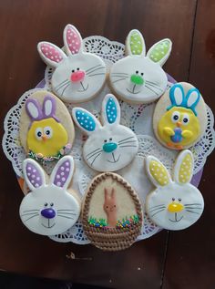 decorated cookies in the shape of easter bunnies on a doily with bunny ears