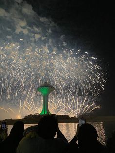 people are taking pictures with their cell phones as fireworks go off in the sky