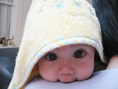 a baby wearing a yellow hat with flowers on it