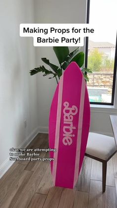 a pink surfboard sitting on top of a hard wood floor