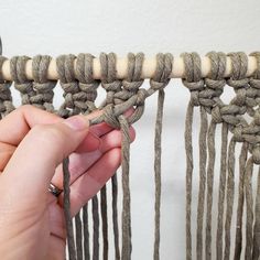 someone is working with yarn to make a wall hanging