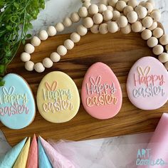 decorated cookies with happy easter written on them sitting on a wooden board next to other decorations