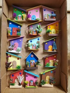 a cardboard box filled with lots of different colored houses and cacti on shelves