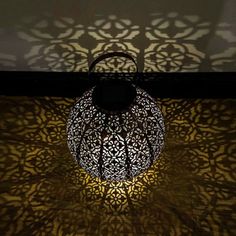 an intricately designed light fixture casts a shadow on the wall