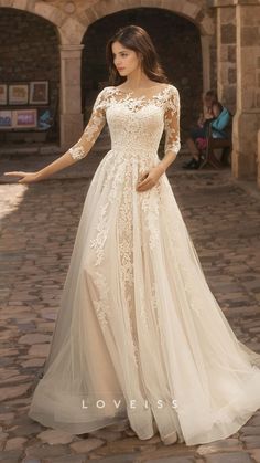 a woman in a wedding dress standing on a cobblestone walkway