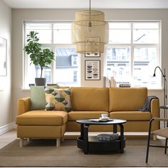 a living room filled with furniture and a lamp hanging over the top of a coffee table