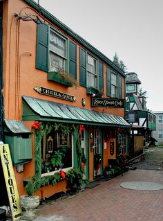 an orange building with green shutters on the front and side windows is decorated for christmas