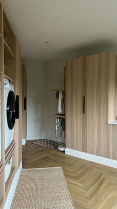 a room with wooden cabinets and an oven in the center, next to a rug on the floor