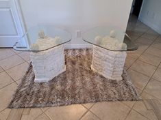 two glass tables sitting on top of a rug