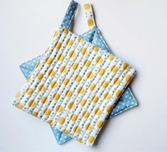 two blue and yellow bibs on top of each other, one with a polka dot design