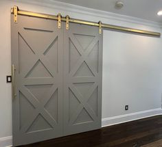 an empty room with two sliding doors on the wall and wood flooring in front of it