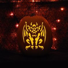 a carved pumpkin with an image of a dragon on it's face in the dark