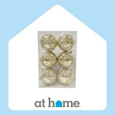 six shiny gold balls in a clear package with the words at home on it's side